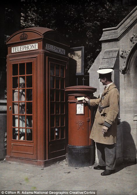 A man posts a letter next to a traditional telephone box in Oxford in 1928