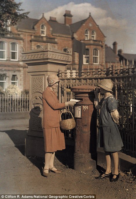 Two girls send a letter at a red pillar box in Belfast in 1927