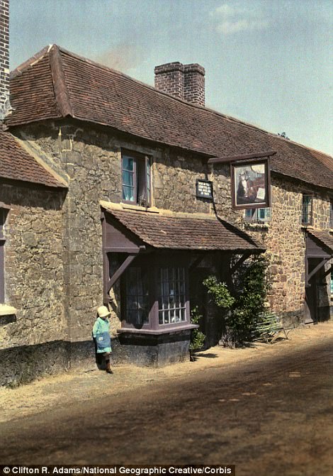 A child stands by The Cat and the Fiddle Inn in Exeter in 1931