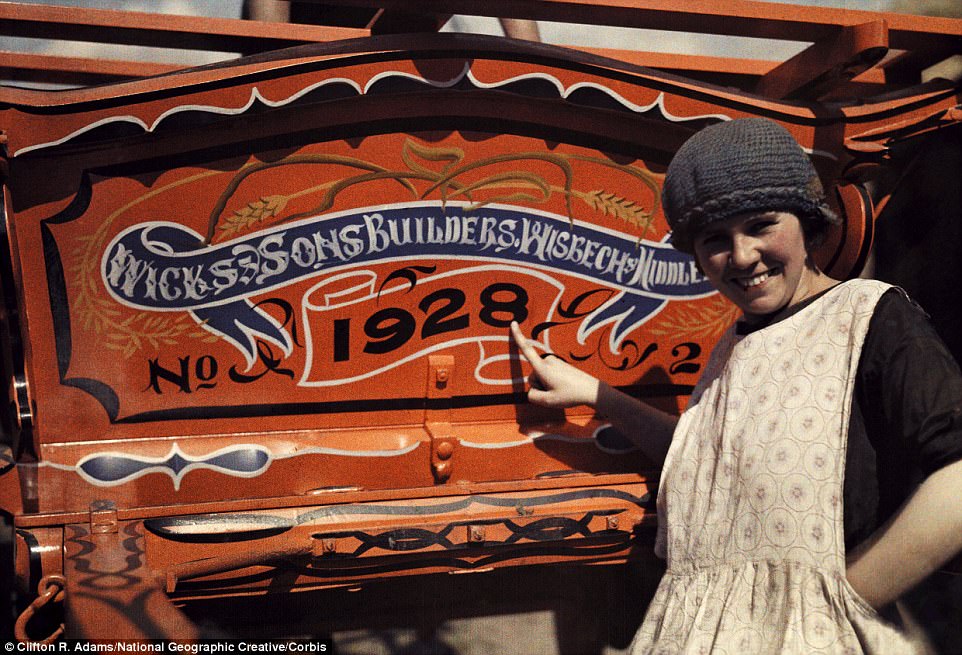 An English woman points to her farm cart in Cambridgeshire, which bears the year before the photo was taken