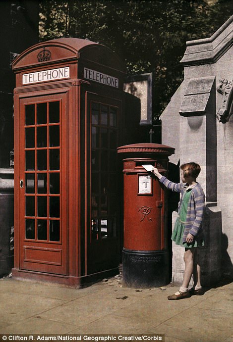 A girl puts an envelope in a postbox in Oxford in 1929
