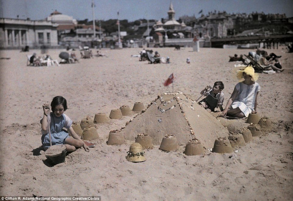 A family builds a sandcastle at the seaside resort of Sandbourne, near Bournemouth in Dorset in 1932