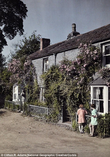 Two girls talk outside a home in Chillington, Devon in 1928