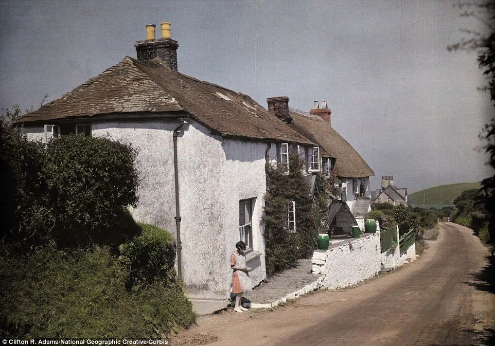 A young girl stands outside her cottage near Clovelly, a village on the coast of North Devon in 1928