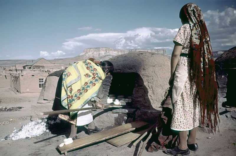 Pueblo women (probably from the Zuni tribe) bake bread.