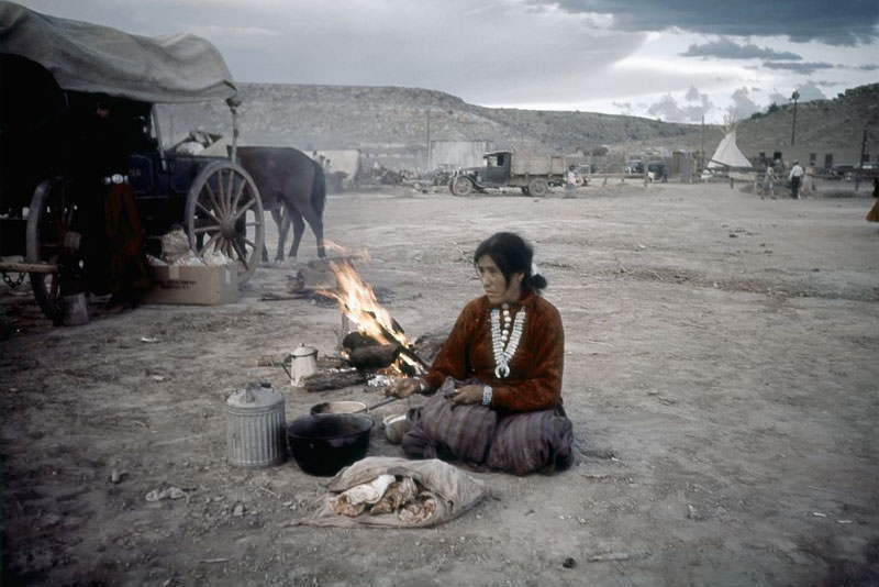 A Native American woman cooks by the campfire.