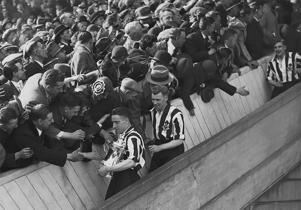 Newcastle United forward Jack Allen (1903–1957, left) is congratulated by fans after the presentation of the FA Cup trophy at the final against Arsenal at Wembley Stadium, 23rd April 1932.