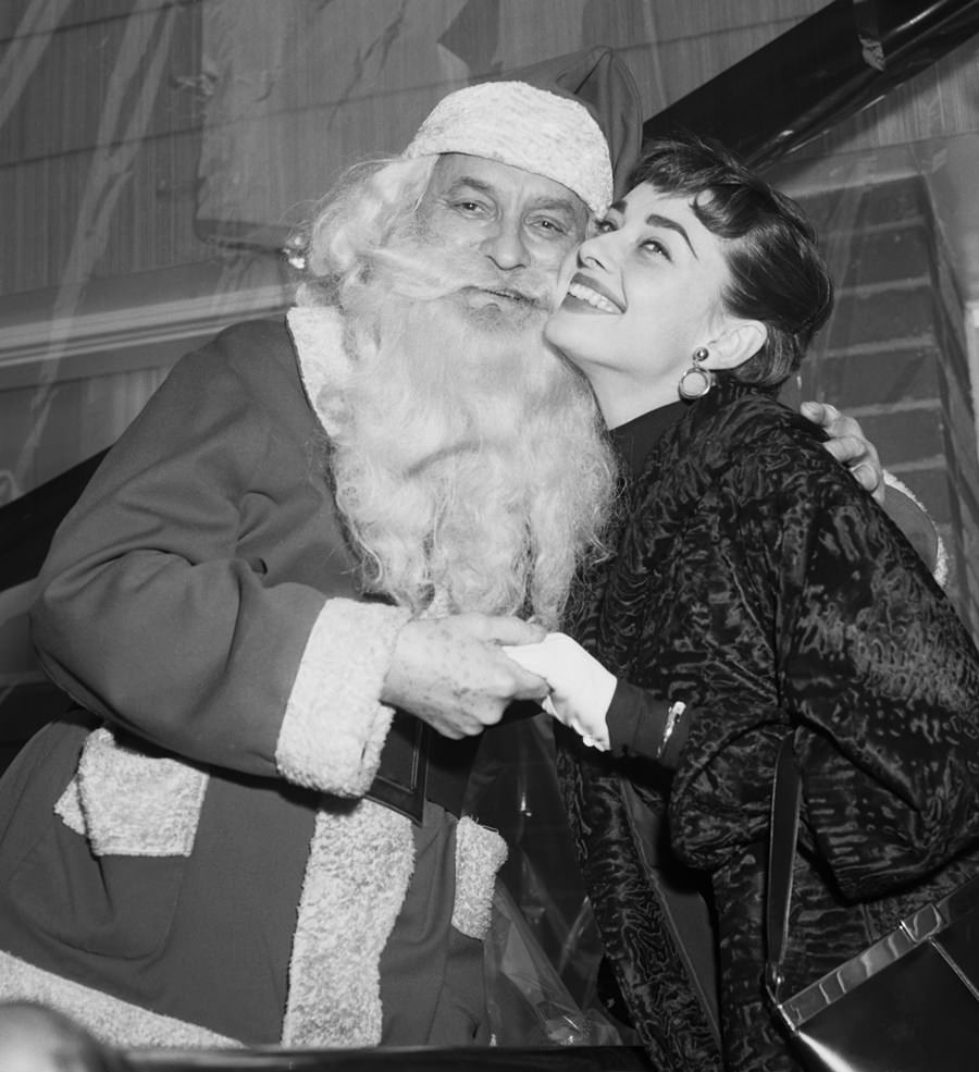 Audrey Hepburn cuddled up to Santa Claus in 1953.