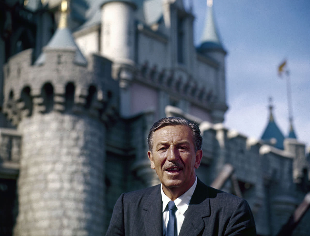 The movie producer and animator Walt Disney smiles as he stands in front of Sleeping Beauty's Castle at the grand opening of Disneyland in 1955