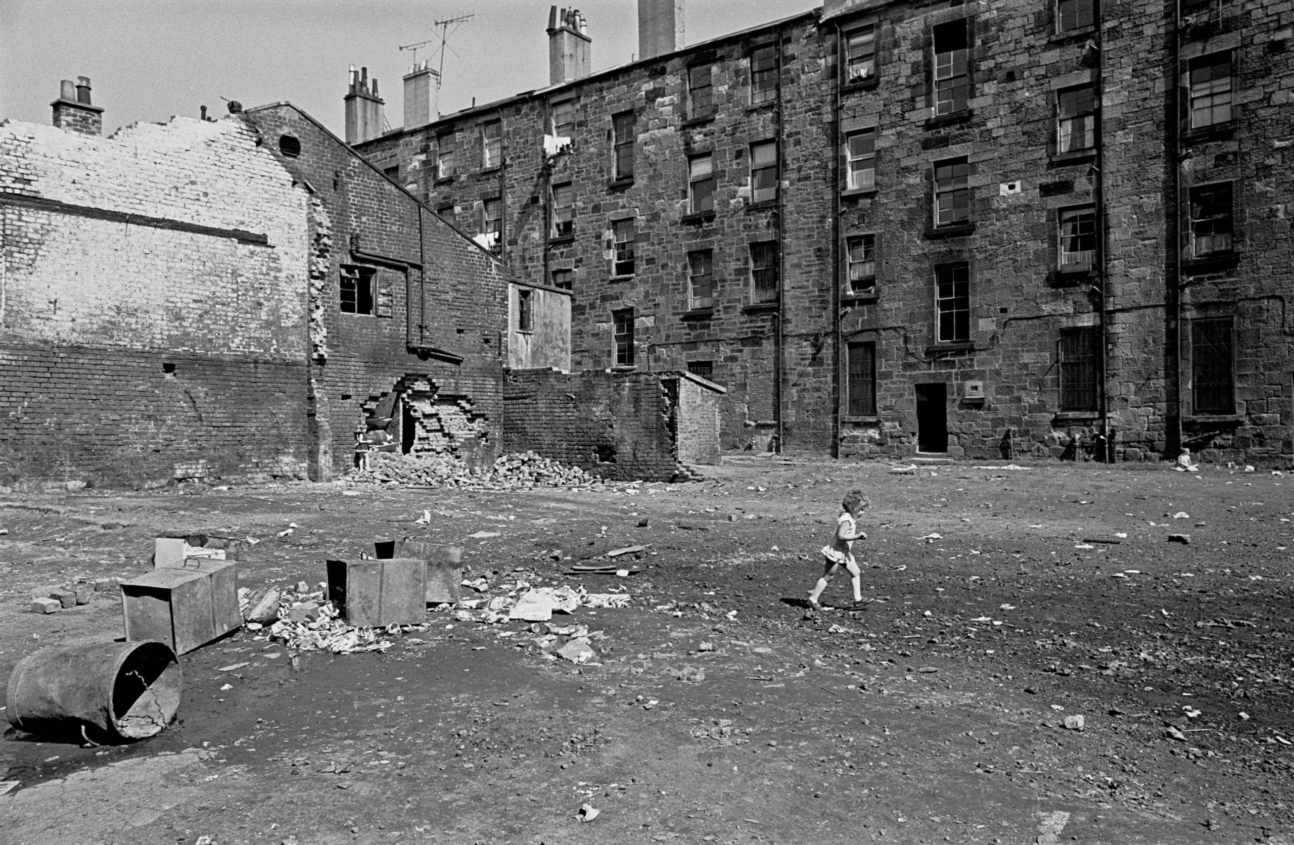 Child crosses a Glasgow tenement courtyard 197
