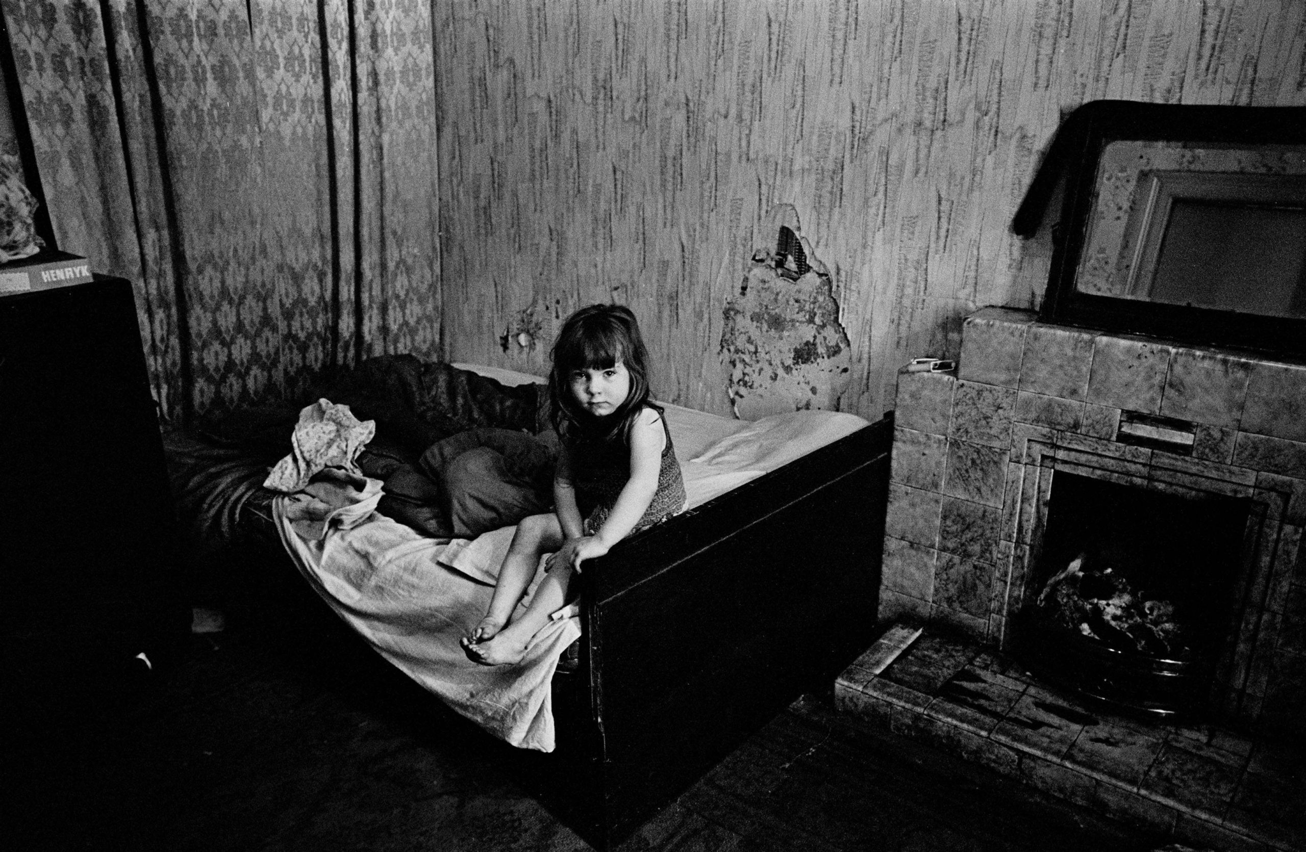 Child in damp semi derelict tenement flat Glasgow 1970
