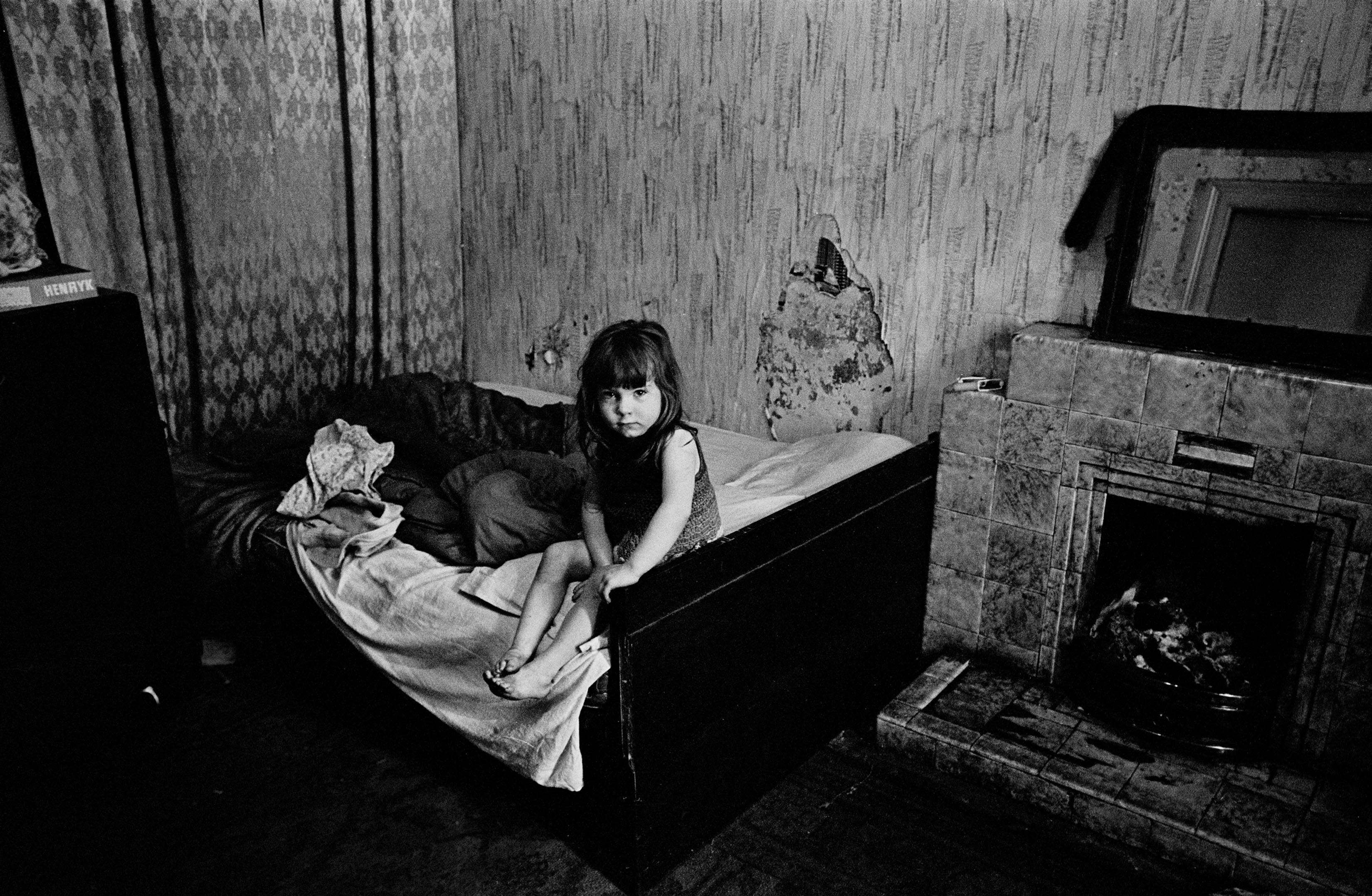 Child in damp semi derelict tenement flat Glasgow 1970