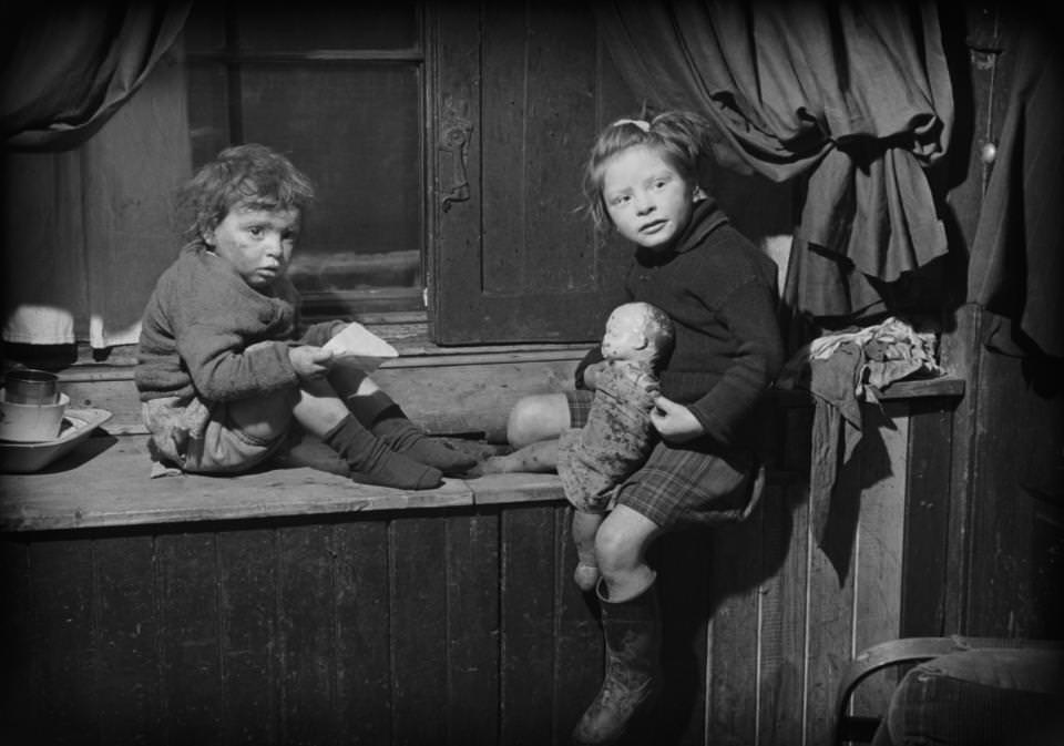 Two children play with their doll as they pose for the camera