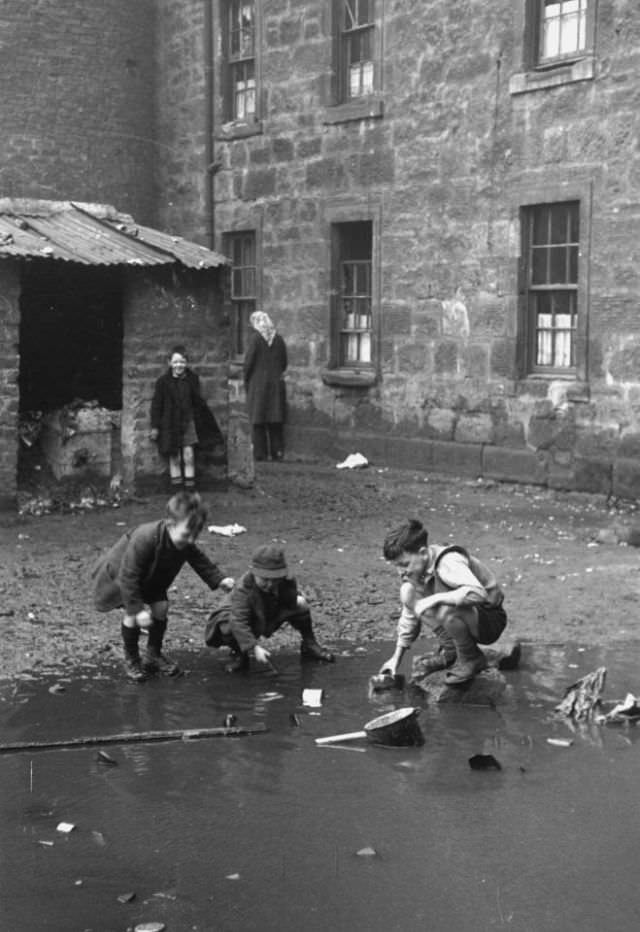 Without many toys to play with, two young lads decide to play a game on a heap of rubbish