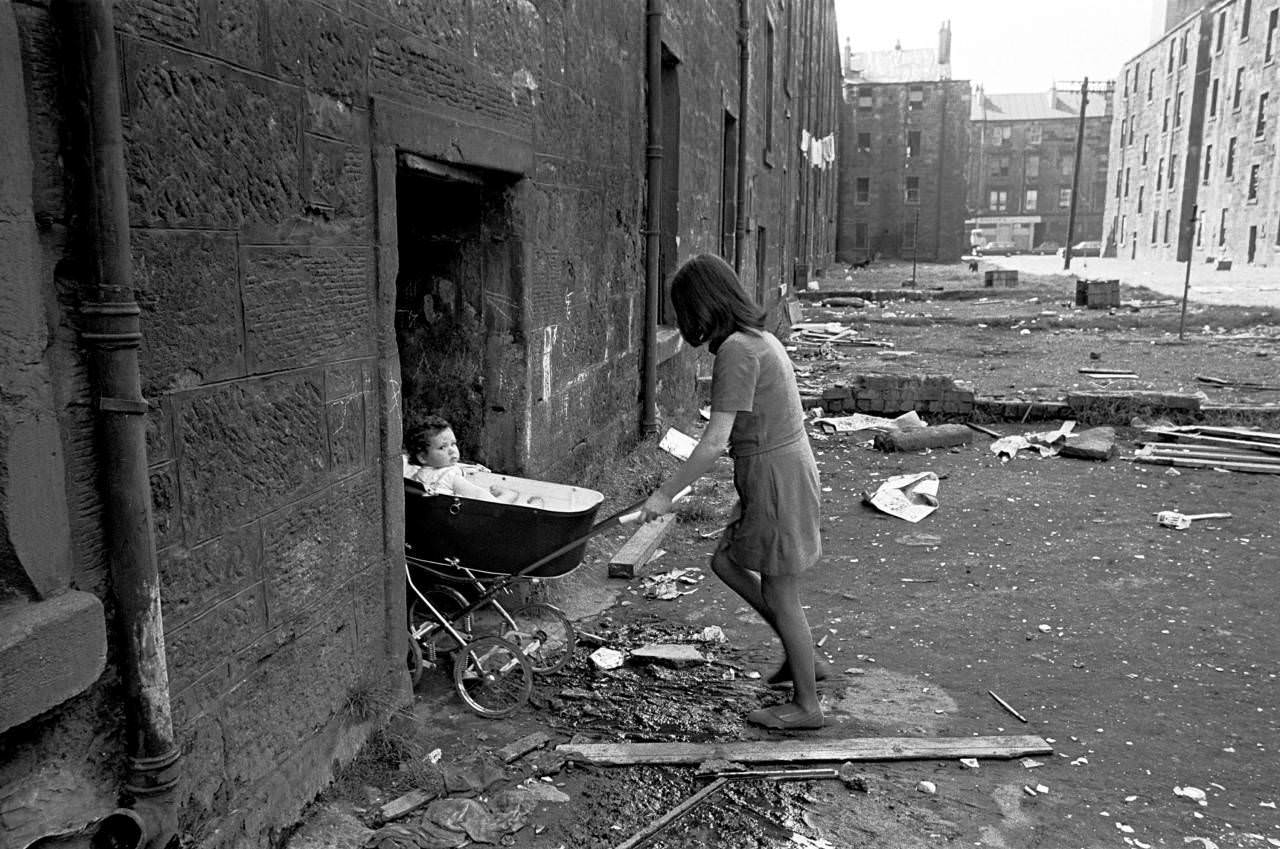 Mother takes her baby inside her condemned tenement block Gorbals 1970