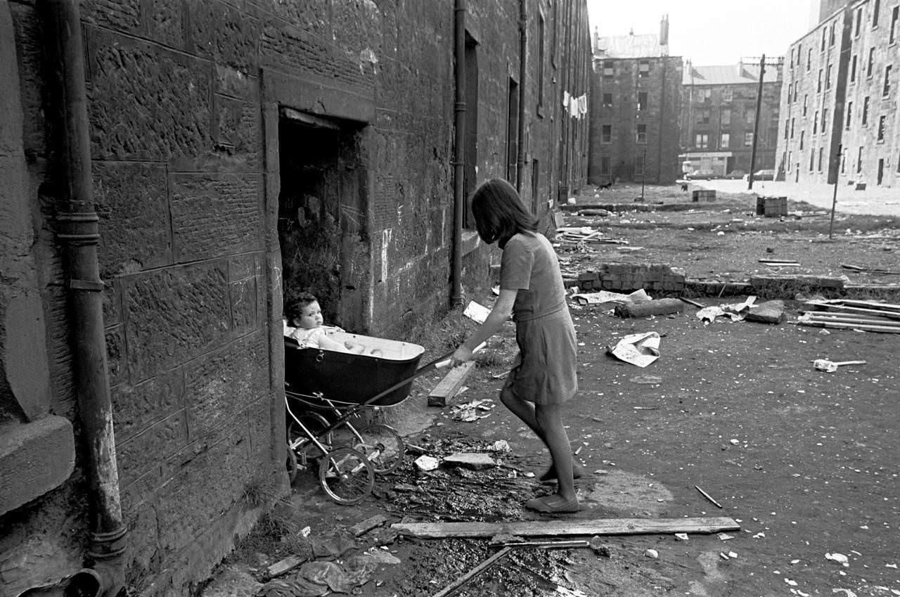Mother takes her baby inside her condemned tenement block Gorbals 1970