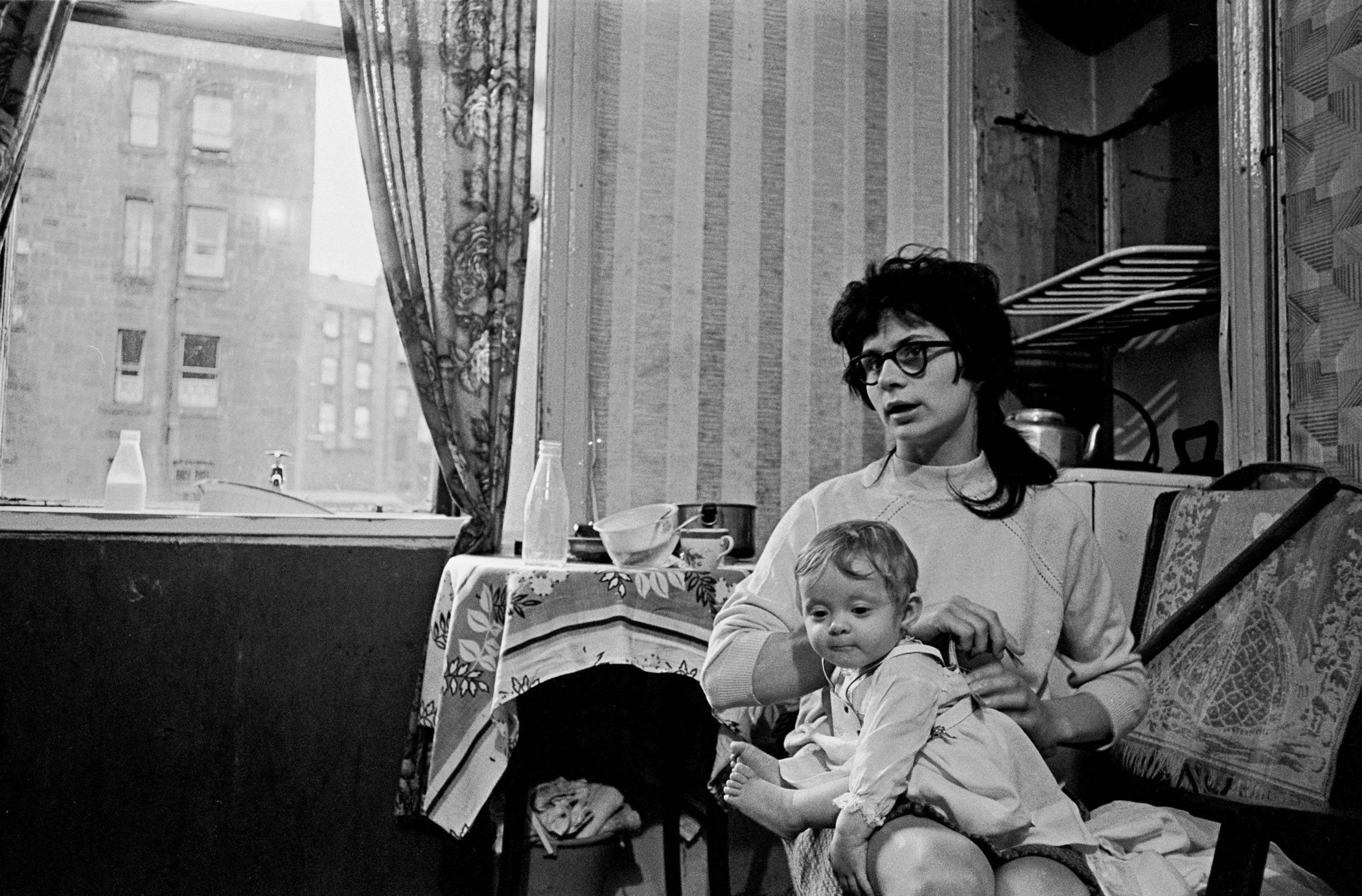 Mother and child living in a damp and semi derelict tenement, Glasgow 1971