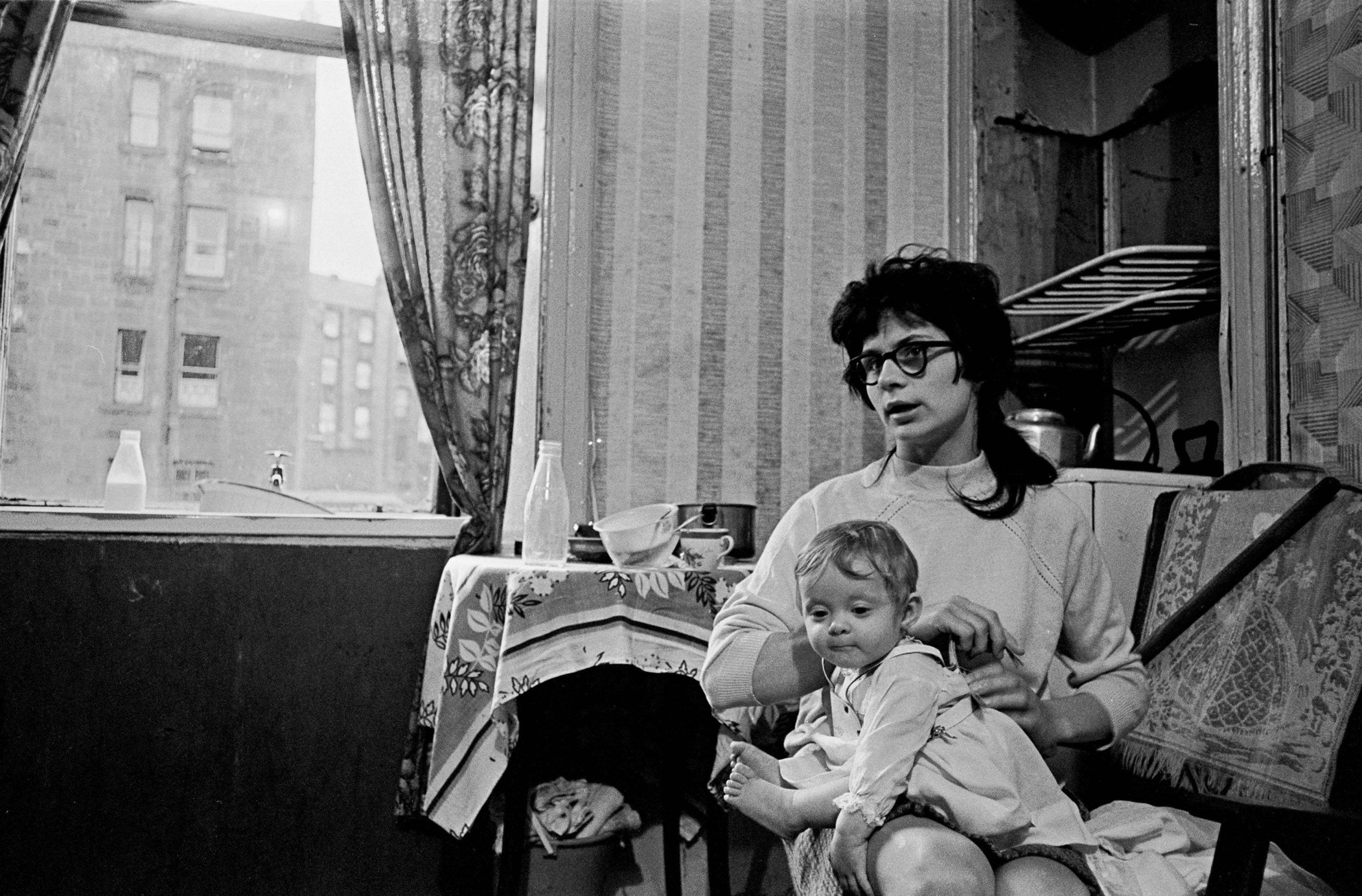 Mother and child living in a damp and semi derelict tenement, Glasgow 1971
