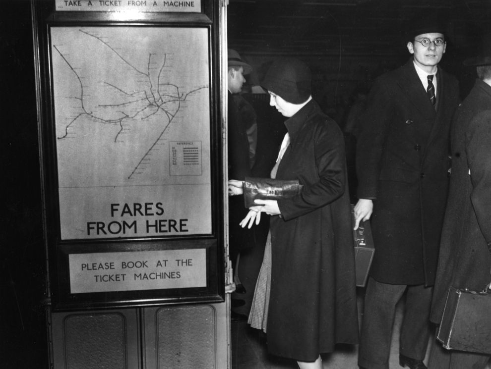 A passenger takes a ticket from the machine at Piccadilly Circus, 1930.