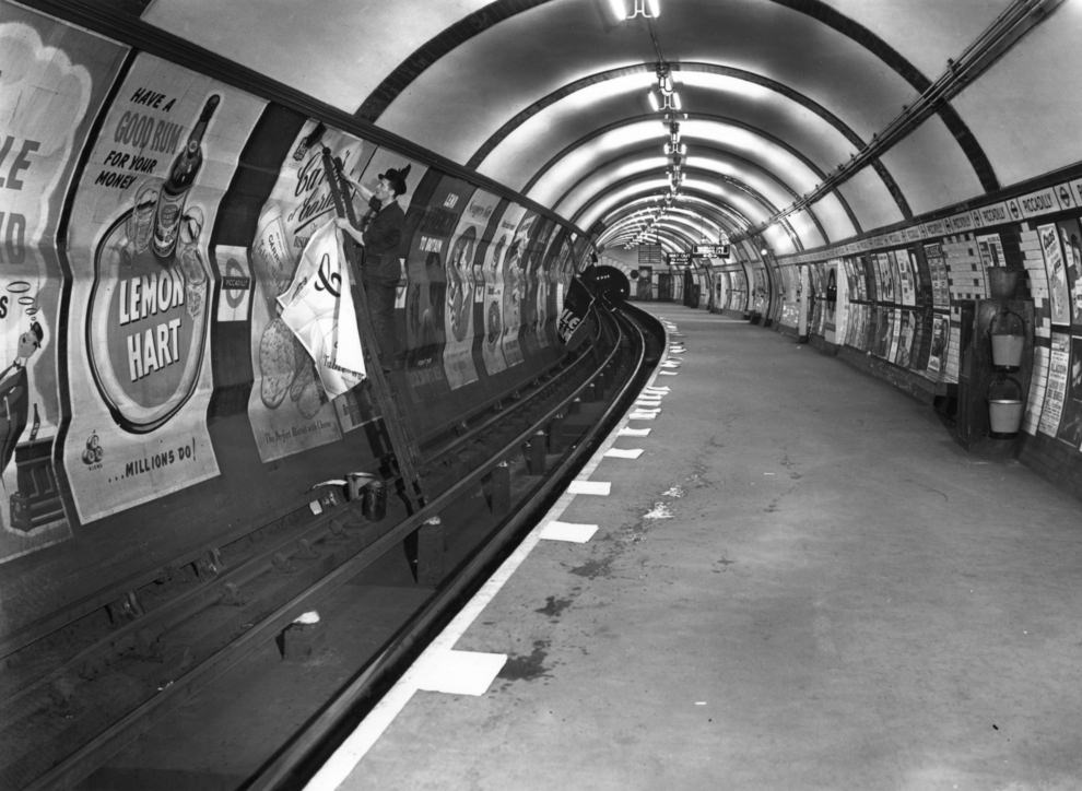 Advertisements being pasted up, 1952.