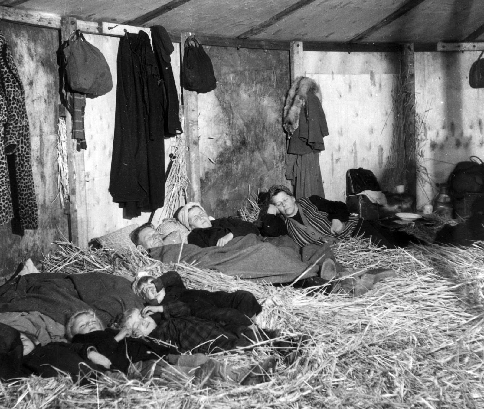 German refugees fleeing from the Russian zone in the first few weeks after the end of World War II in Europe, seen on Oct. 25, 1945. They are sleeping on straw in a makeshift transit camp at Uelzen in the British zone of Germany.