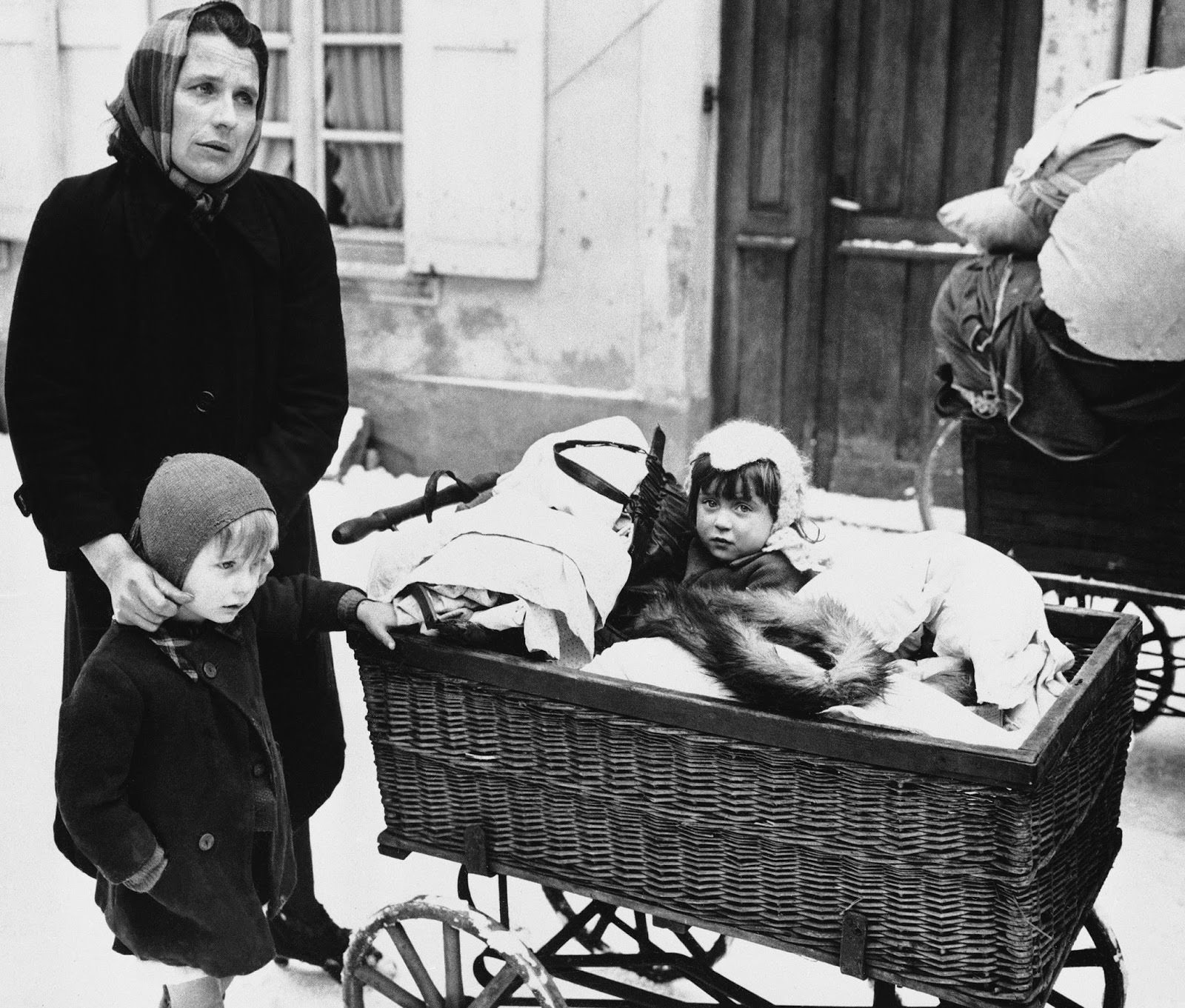 A Frenchwoman with two children and belongings loaded on a baby carriage seen in Haguenau, France on Feb. 20, 1945, before they started on their long trek to a safe rear area. They are some of the refugees leaving the town because of the planned withdrawal of the 7th U.S. Army.