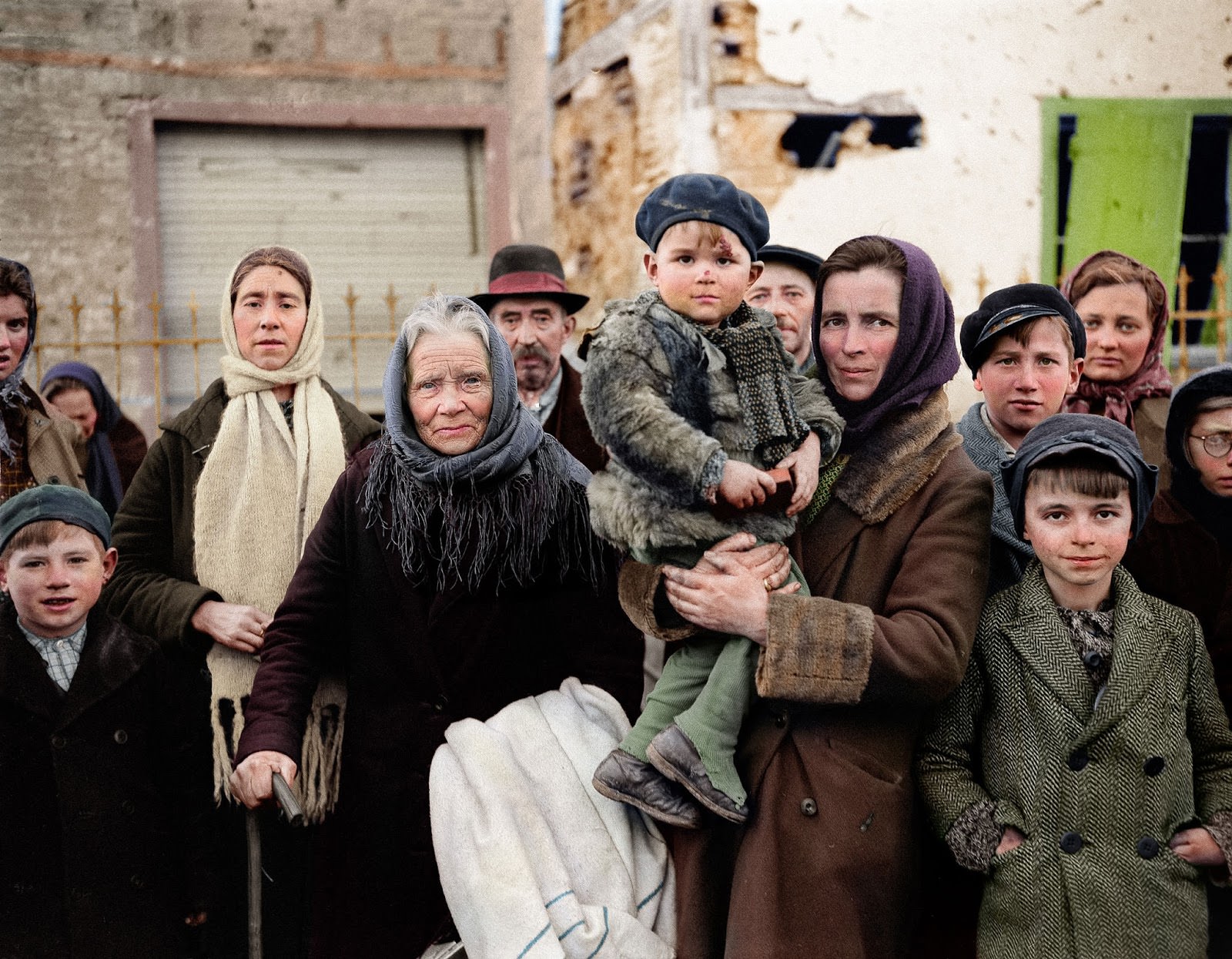 Refugees stand in a group on a street in La Gleize, Belgium on Jan. 2, 1945. They are waiting to be transported from the war-torn town after its recapture by American forces during the German thrust into the Belgium-Luxembourg salient.