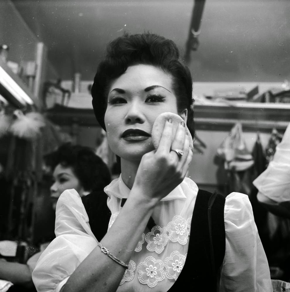 A chorus girl at the Forbidden City nightclub adds the finishing touches to her makeup.