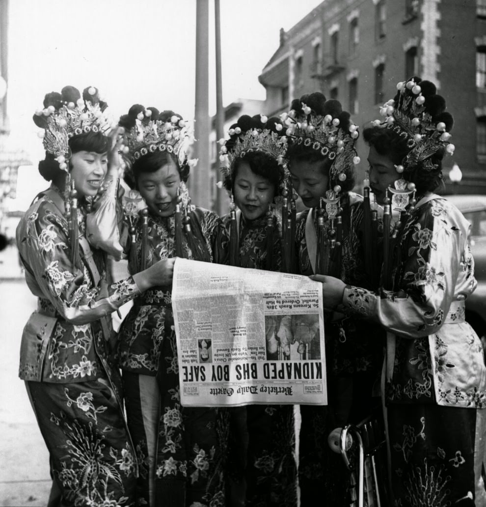 Five women dressed in traditional Chinese clothing read the day’s headlines.