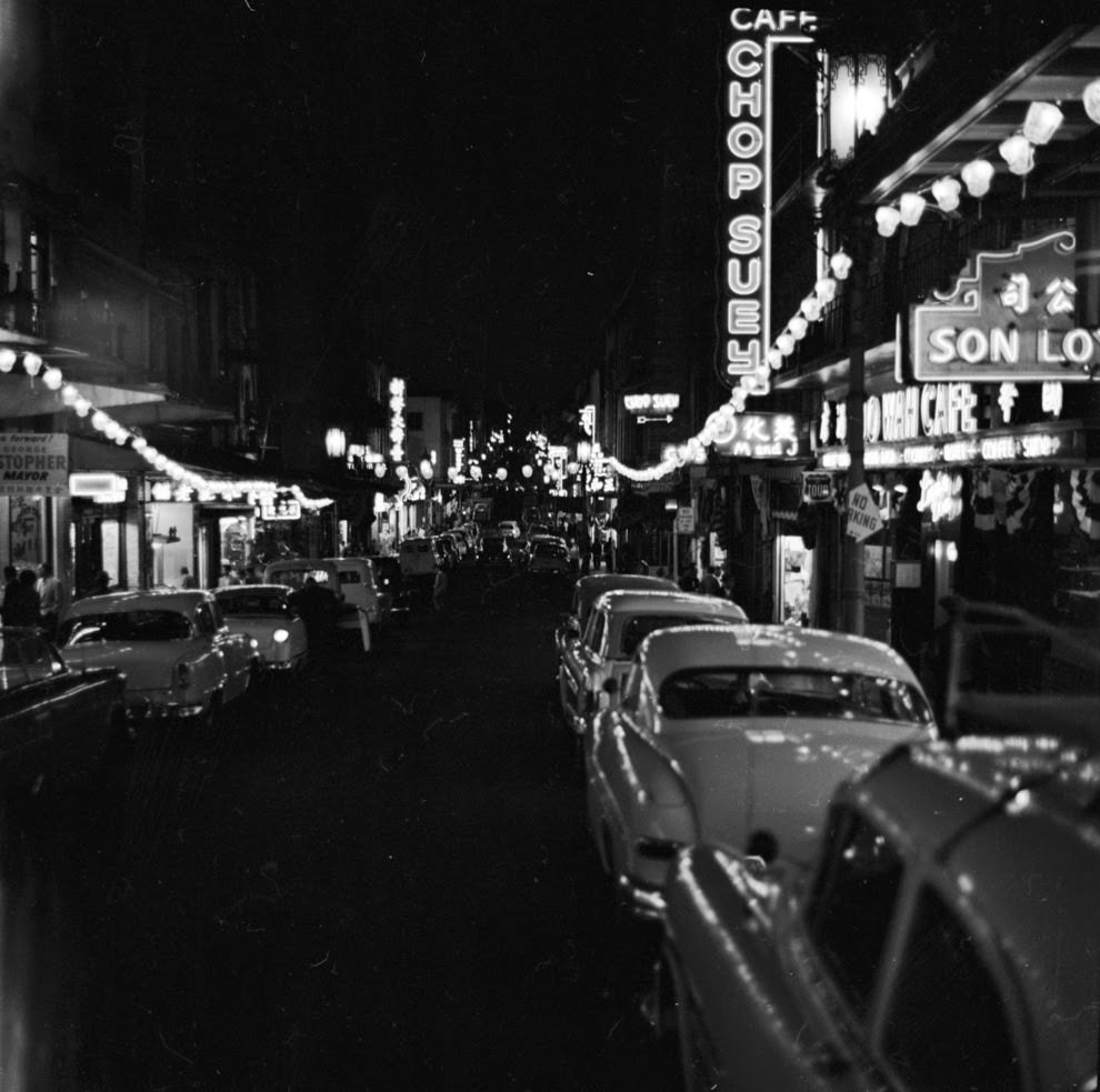 Grant Avenue is lit up by the string lights and neon signs of restaurants.