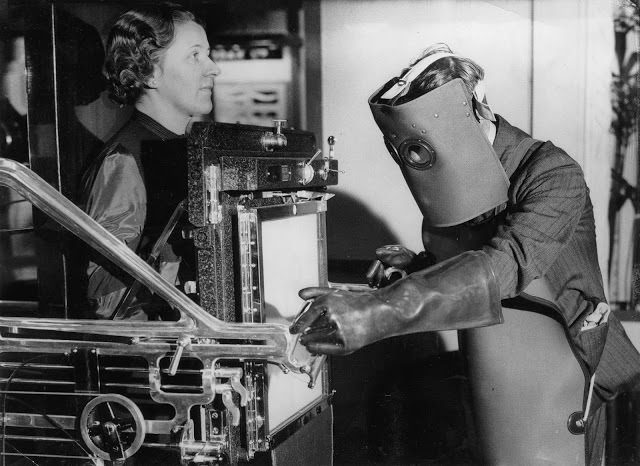 A legújabb röntgenberendezés radiológus által üzemeltetett, a régi típusú védőeszközöket viseli, amelyekre a modern készülékeknél már nincs szükség.  Radiológiai kiállítás.  Központi terem.  Westminster, 1934.