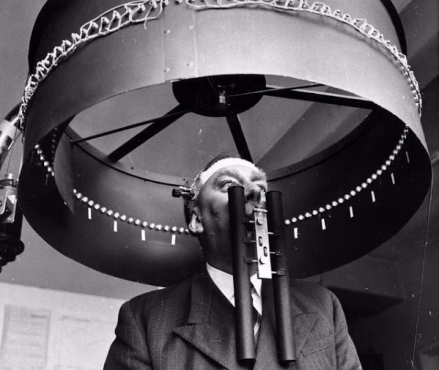 Dr G. H. Byford stands under an optokinetic drum wearing a contact lens with a miniature lamp cemented to the lens, during an experiment to investigate the reflex movements of the eyes and their association with visual illusions, at the RAF Institute of Aviation Medicine in Farnborough, 1960s.