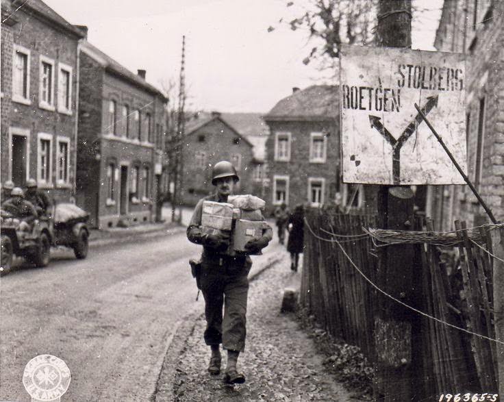 US Army Sergeant Joseph H. Kadlec delivering Christmas packages sent from home, near Aachen, Germany, 14 Nov 1944.