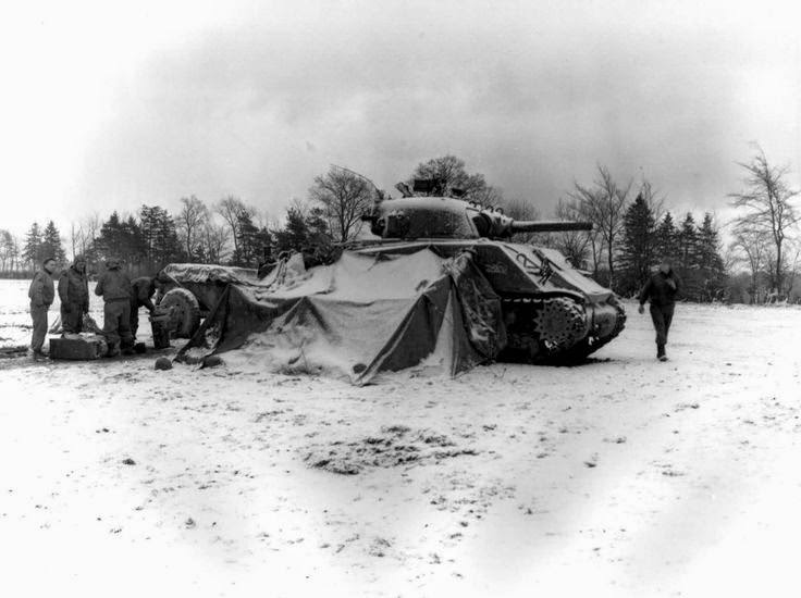 US 5th Armored Regiment tankers gathering around a fire and opening Christmas presents, near Eupen, 30 december 1944; note M4 Sherman tank.