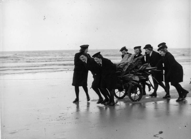 The Women's Royal Naval Service: Wrens pushing a hand cart full of salvaged driftwood on the beach at Blundell Sands near Liverpool, ready for the fire at the children's Christmas party which they are holding at their hotel.
