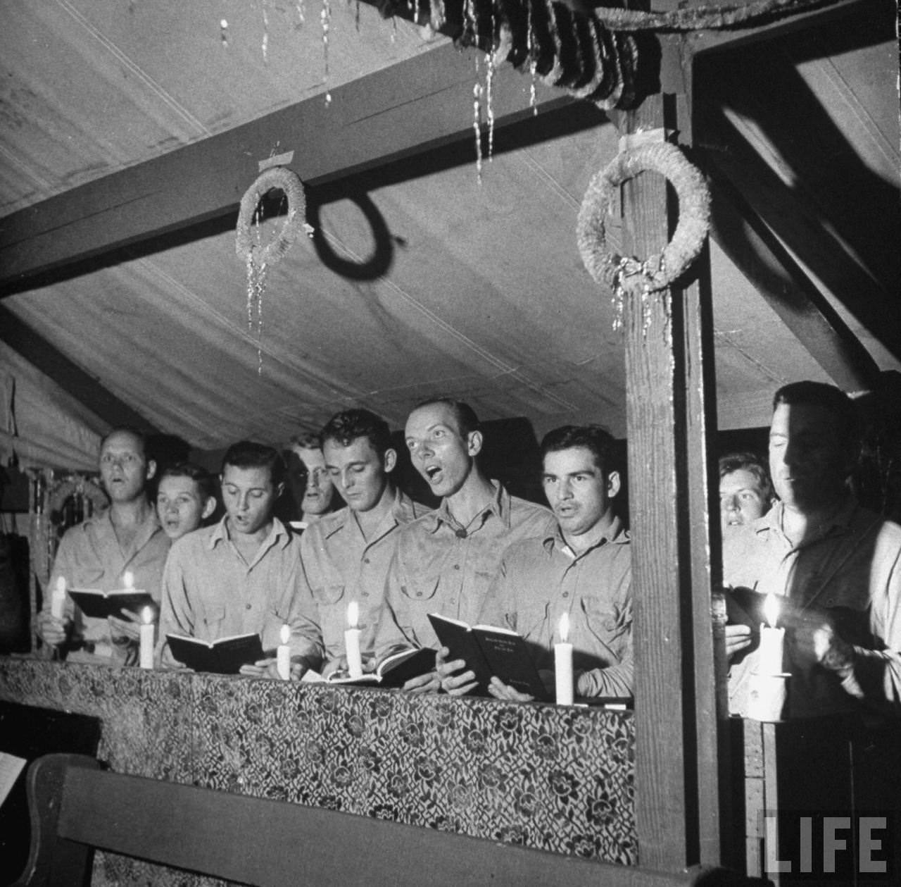 Singing and lighting candles at midnight mass, Guadalcanal, Solomon Islands, 1942.