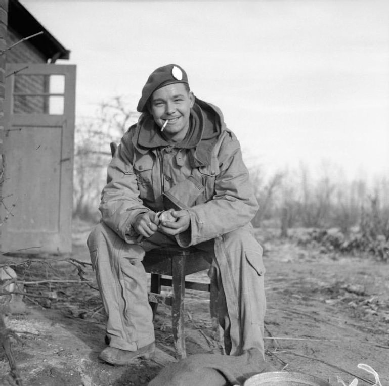 British soldier peeling potatoes for Christmas dinner, Germany, 1944.