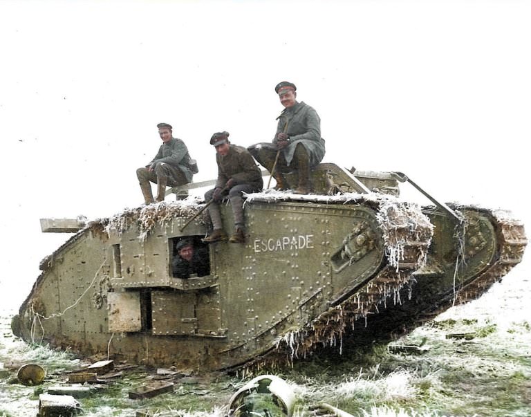 German soldiers on board a tank which bears the word escapade on the side. Three sit on the top while another leans out of the window.