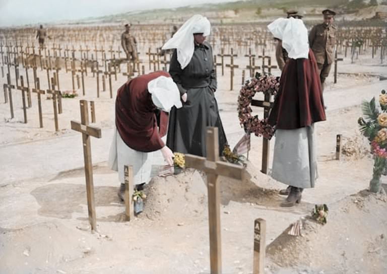 Nuns laying wreaths in a field of mass graves. The total number of military and civilian casualties in World War I was around 40million.