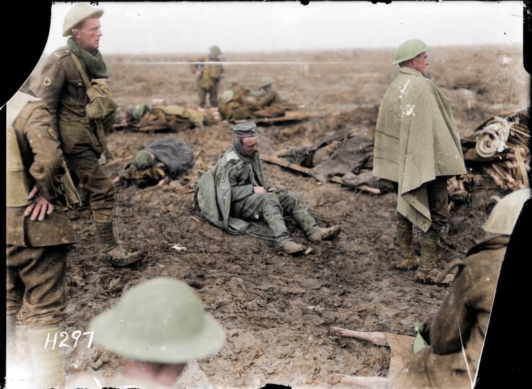 French soldiers at the Battle of Verdun. One sits on the mud as others help the wounded.