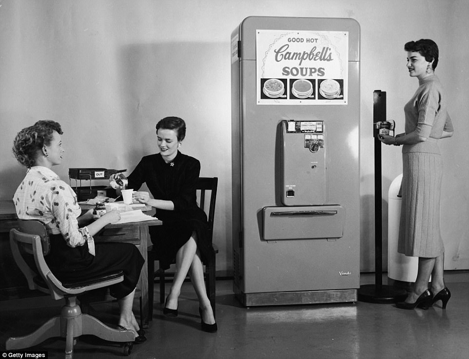 Three women enjoy soup from a Campbell's Soup vending machine in their office, one of the woman opens a can of soup using another nifty gadget, a floor-mounted can opener, ca. 1950s.