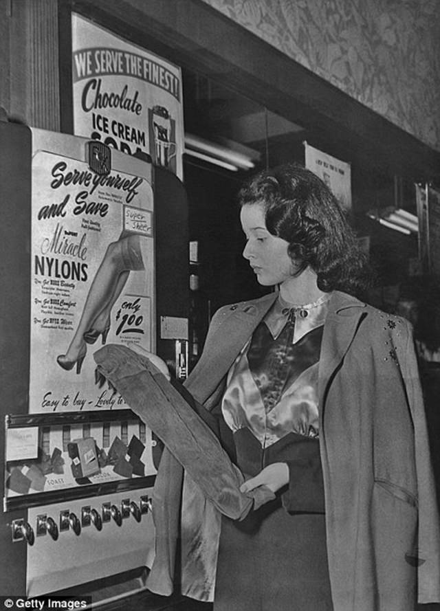 A woman also purchases a pair of nylon stockings from a machine, ca. 1950s.