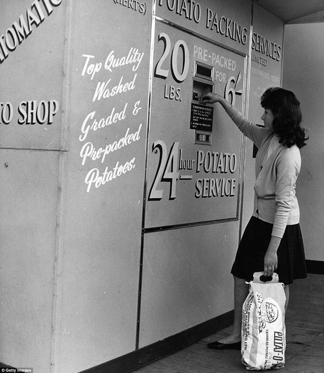 A woman is operating the first potato vending machine in Britain in Chelsea, 1962.