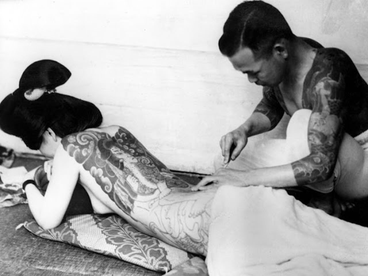 Woman being tattooed, ca. 1940s.