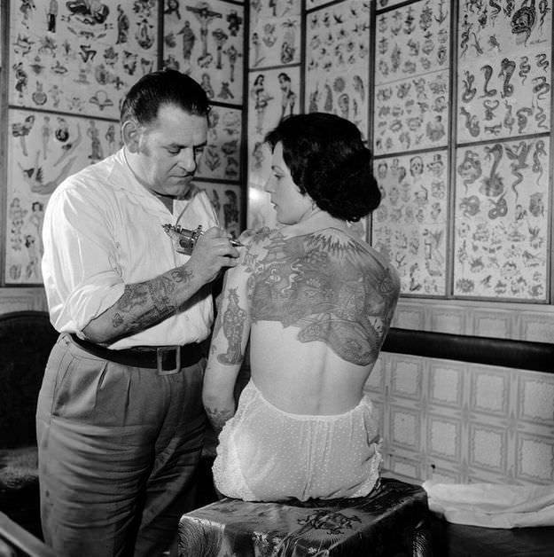 Pam Nash, a champion tattooed lady, with a Japanese garden scene across her back, 1960s.