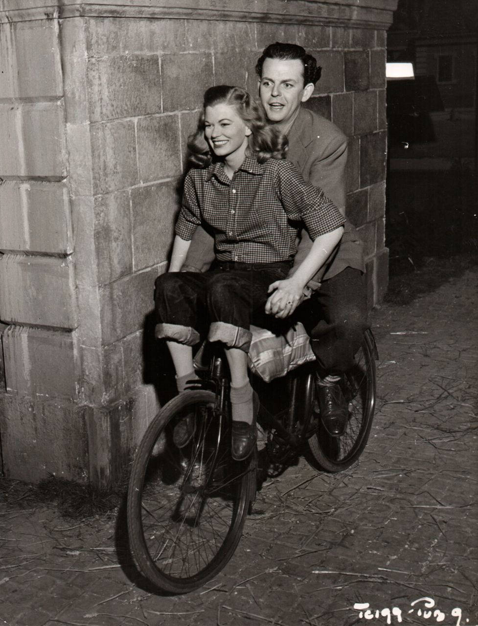 Helen Backlin and David Tomlinson riding a bike, 1949