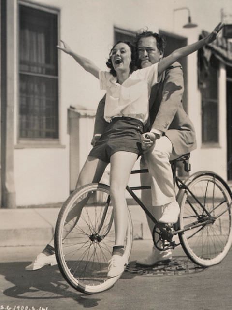 Andrea Leeds and Edward Arnold riding a bike, 1936