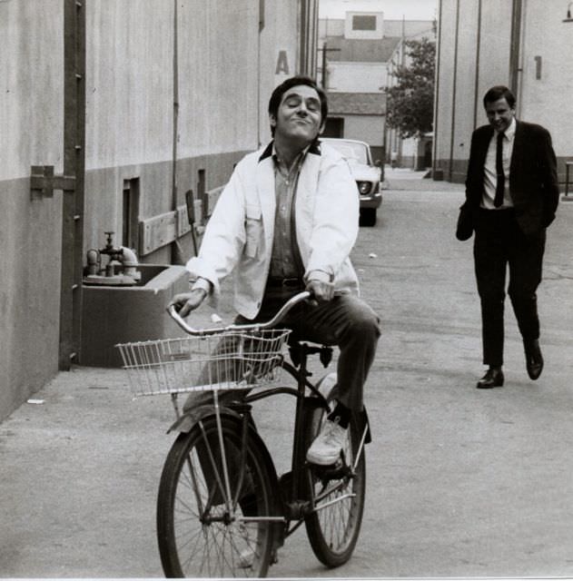 Anthony Newley riding a bike, 1967