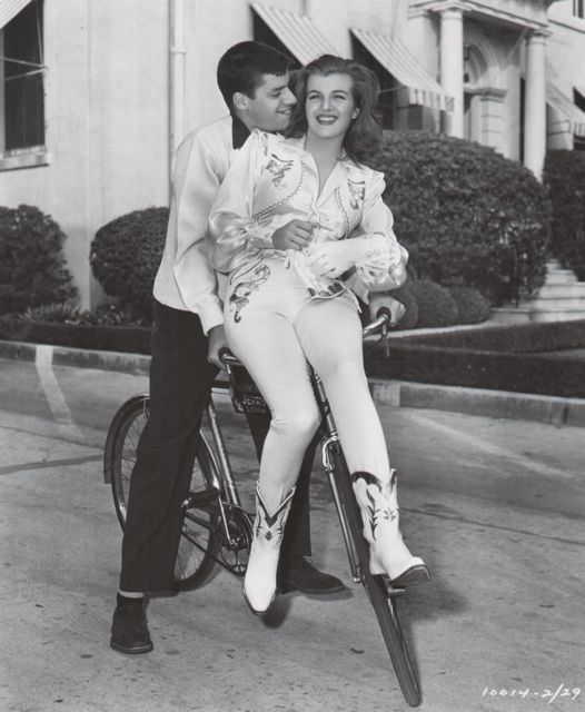 Jerry Lewis and Corinne Calvet ride a bike.