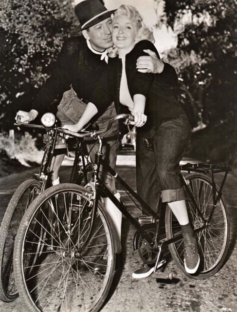 Barry Sullivan and Lana Turner riding bikes.